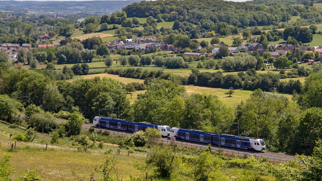 Een trein rijdt door het heuvelachtige landschap van Zuid-Limburg
