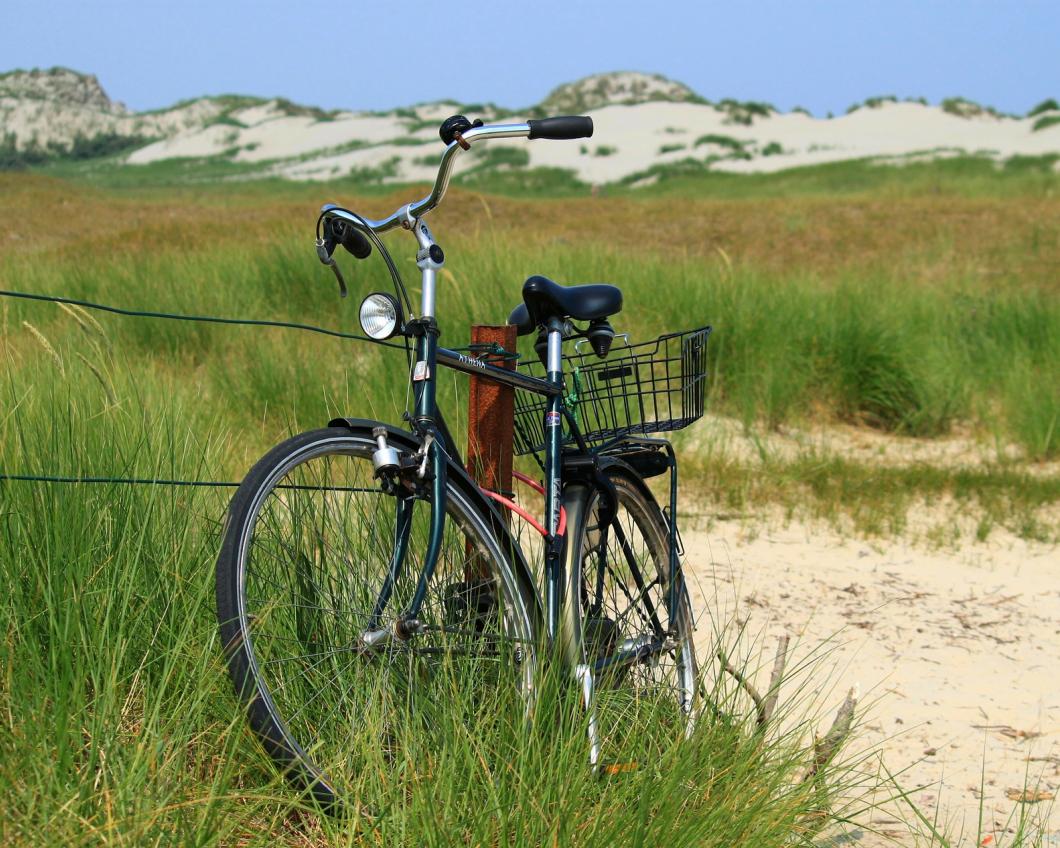 Een fiets staat geparkeerd in de duinen