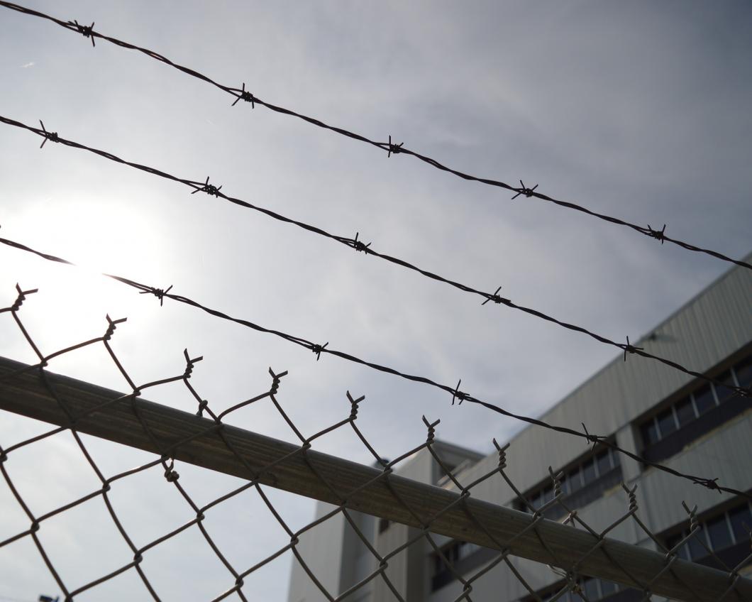 Prikkeldraad boven een hek in de gevangenis