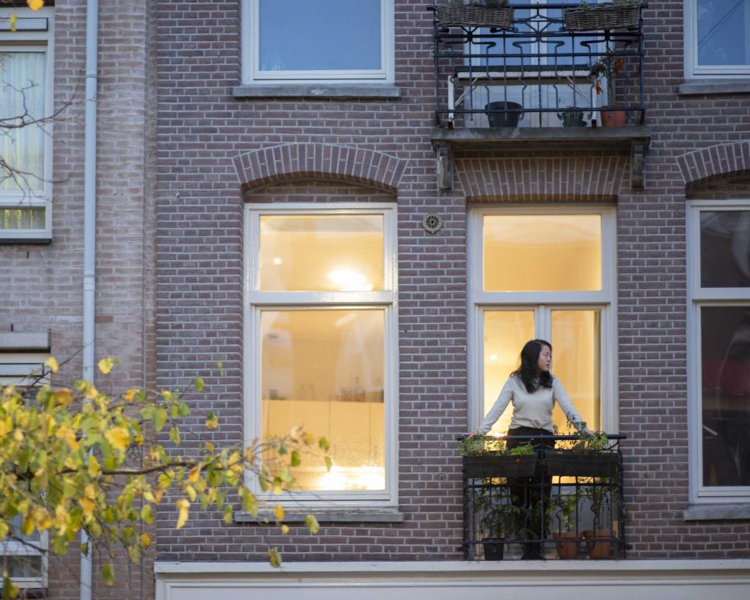 Vrouw op balkon van een woning