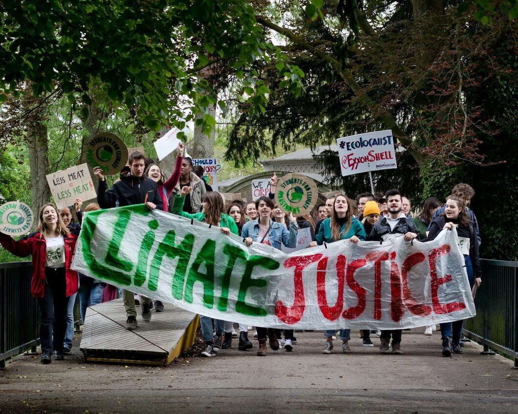 Een groep jongeren met een klimaatprotest vlag