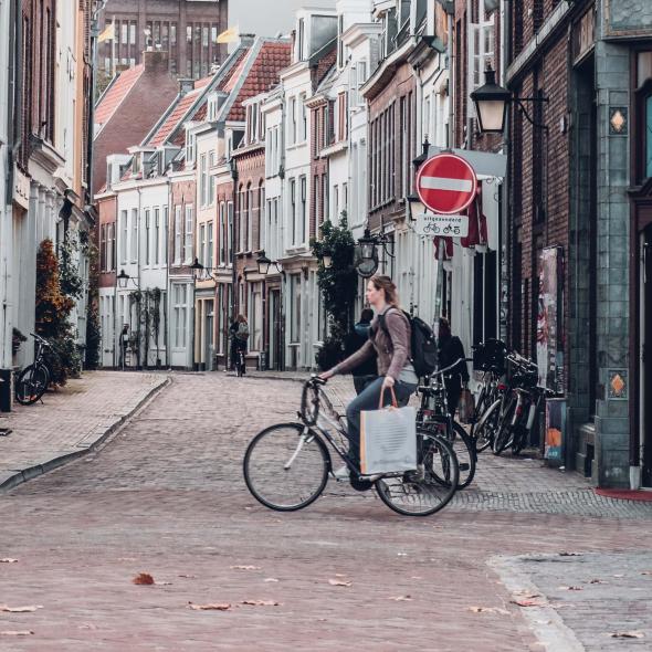 Een fietser fiets door de binnenstad van een verlaten Utrecht