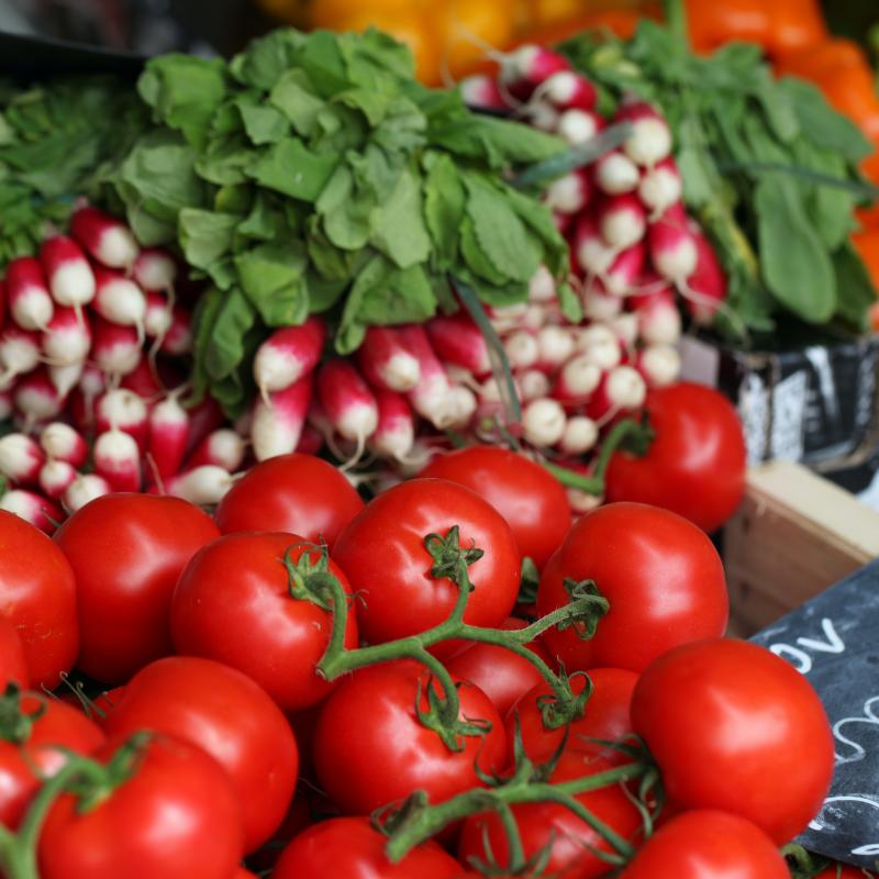Tomaten en radijsjes uitgestald op een marktkraam.